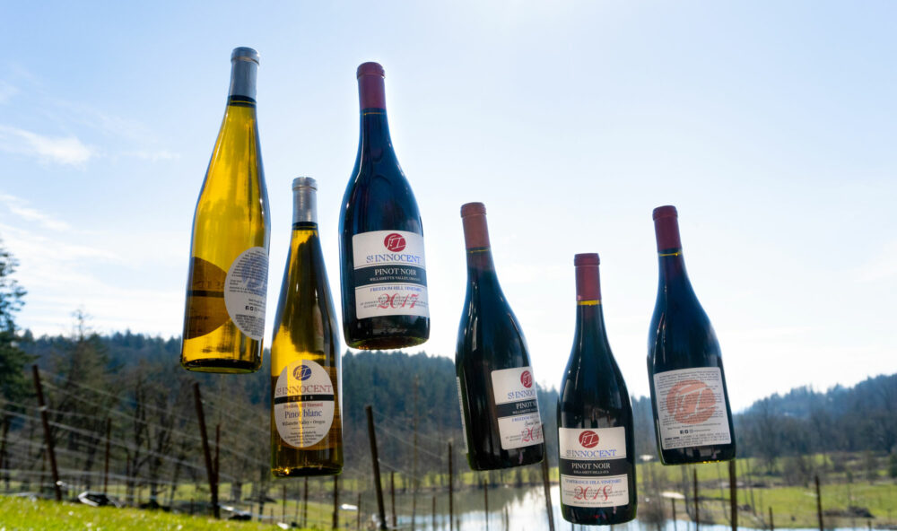 6 bottles of wine that appeasr to be floating over the St. Innocent vineyard