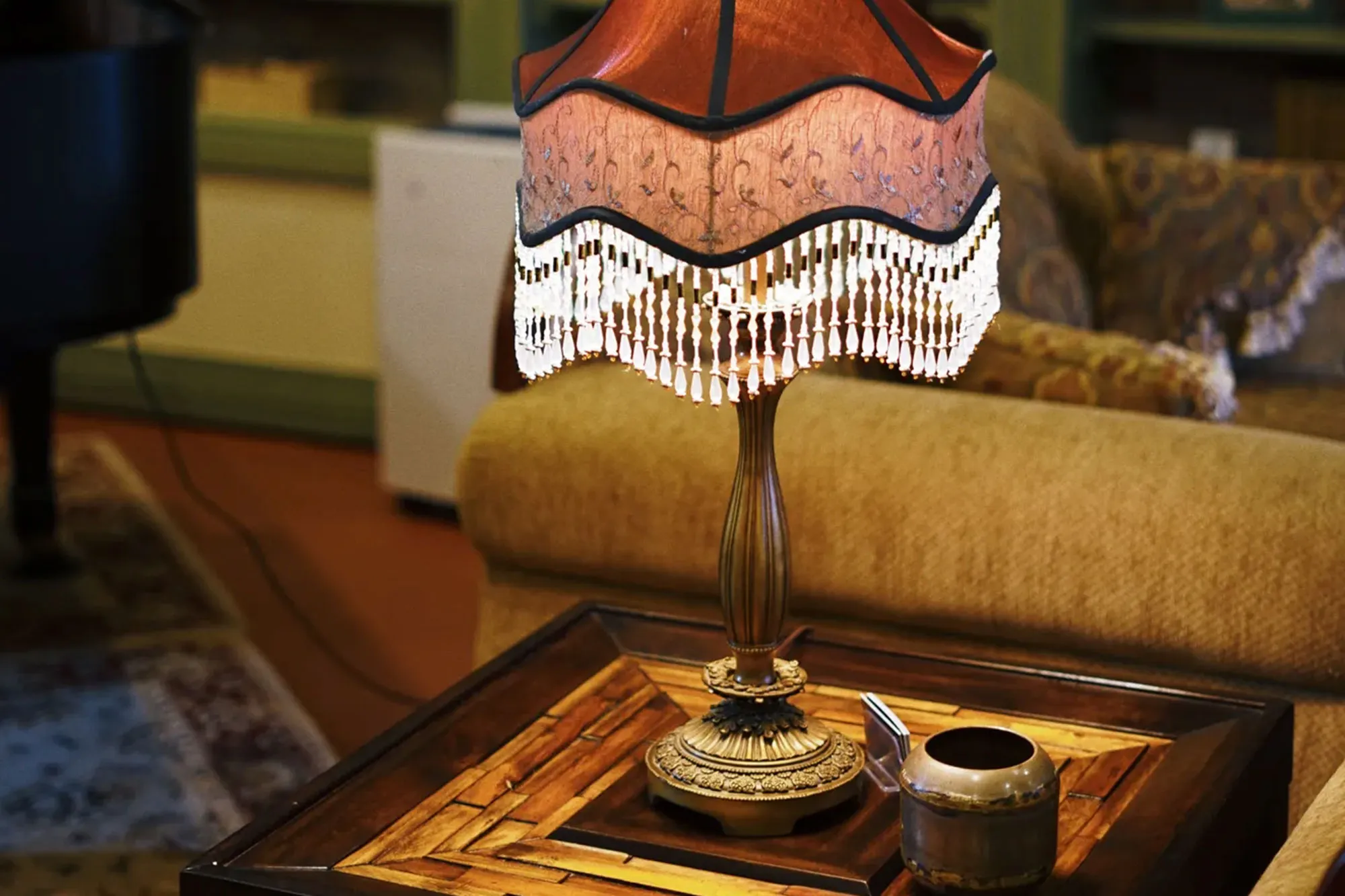 Antique lamp with beaded shade on a side table